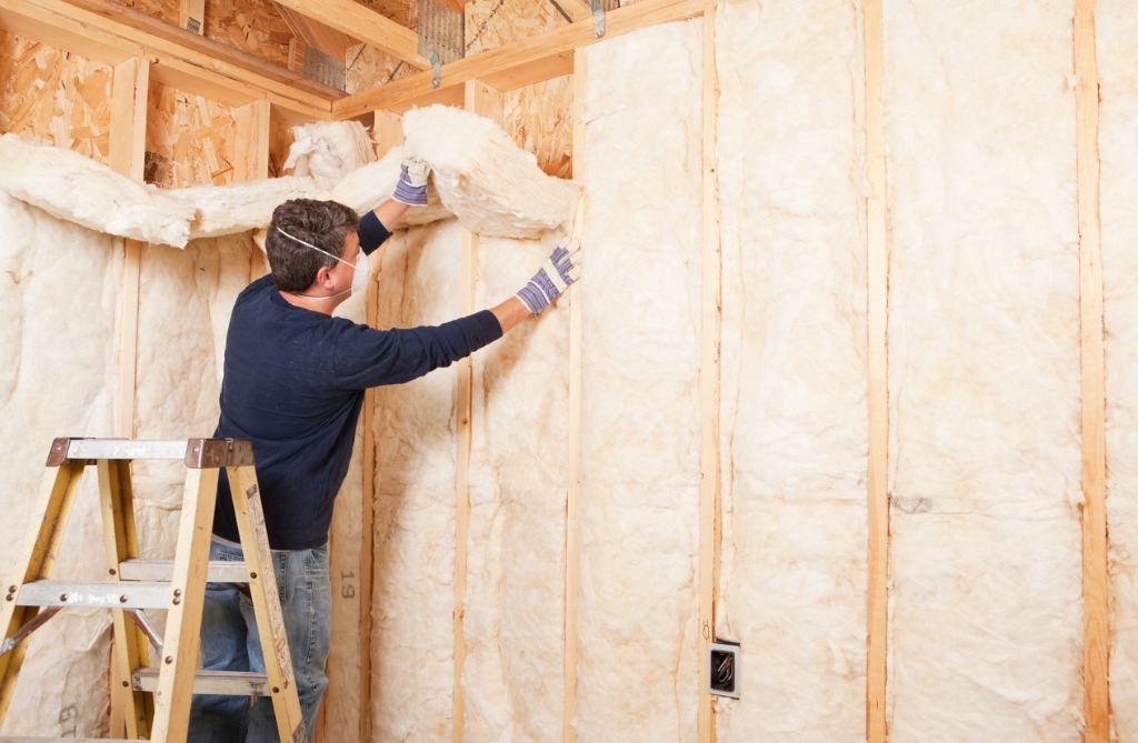 Construction-worker-installing-fiberglass-insulation
